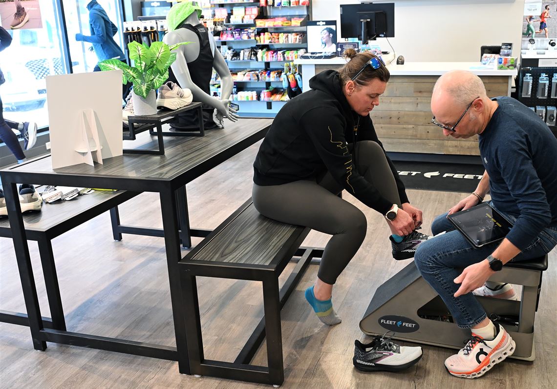 Jon Fisher, training program manager for Fleet Feet in Bakery Square, helps Megan Kruse of Monroeville find the right shoe.