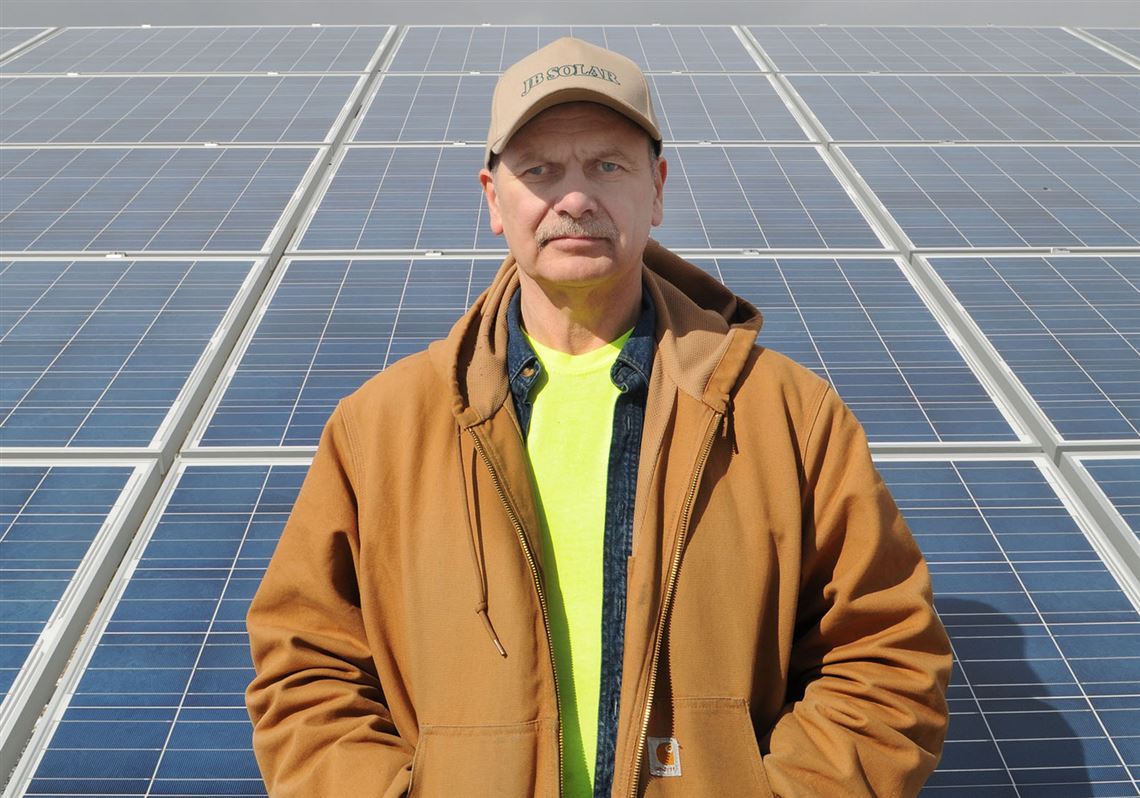 Jeff Balles, owner of JB Solar LLC, with the solar panels he uses to produce electricity to sell as well as power his own home. Regulations proposed by the Public Utility Commission could harm Balles' solar business. 