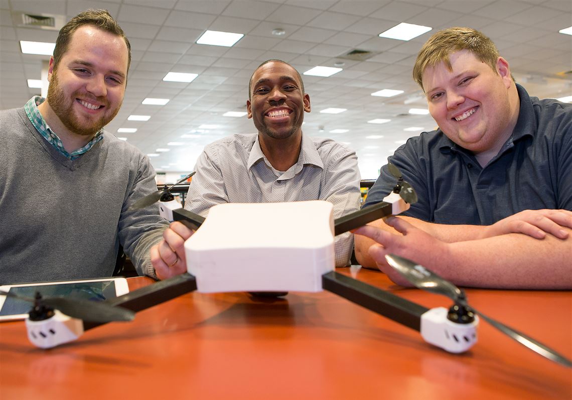 From left, Ares Drones co-founders Ben Brautigam, Sherwyn Saul and Justin Miller pose with their quadcopter prototype Ares One after a demo flight at Settlers Cabin Park in Robinson.