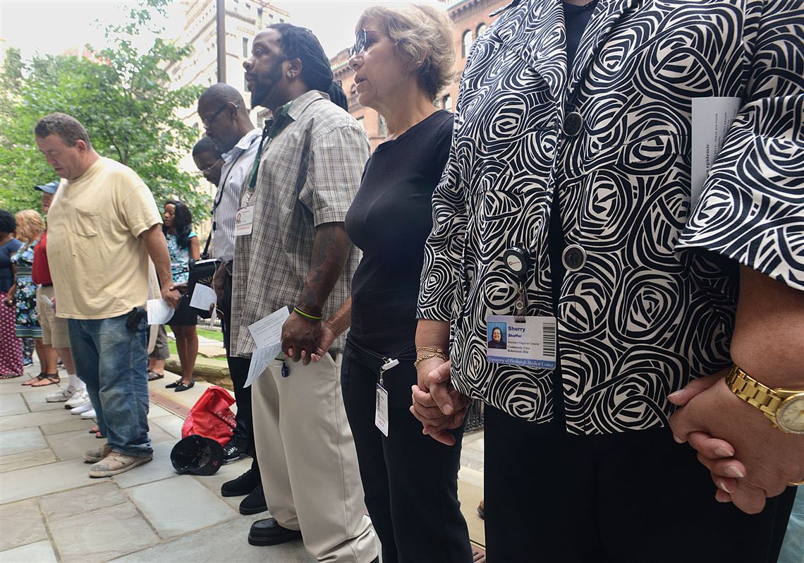 People gather hand-in-hand in prayer Monday outside the Trinity Episcopal Cathedral, Downtown, to mark Overdose Awareness Day.