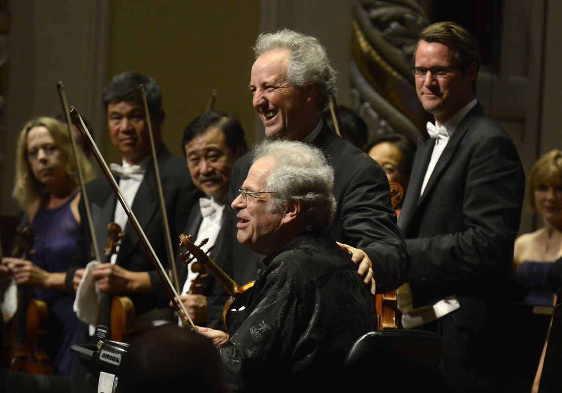 Violinist Itzhak Perlman, center foreground at the end of his performance, with Manfred Honeck, PSO music director at Cinema Serenade of the Pittsburgh Symphony Orchestra, at Heinz Hall on Sept. 12, 2015.