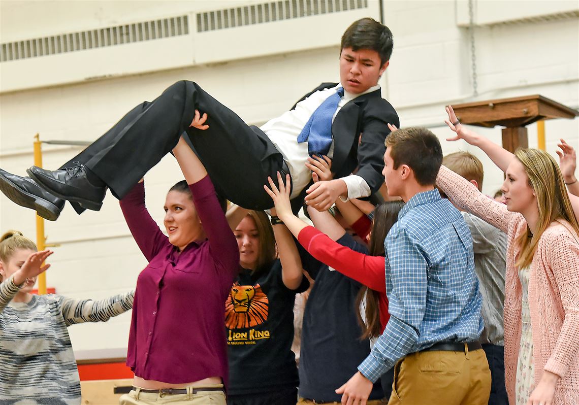 Students in the St. Sebastian Youth Ministry carry off Calvin Chumura as a contemporary Christ as they rehearse 