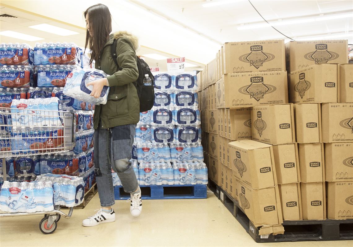 Mengxi Tan, a student at Carnegie Mellon University and resident of Shadyside, stocks up on bottled water following the the water advisory issued Tuesday evening. 