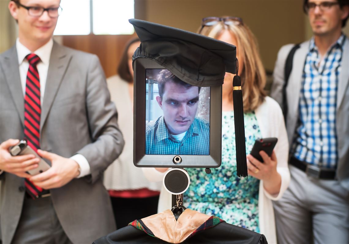 Soon-to-be-graduate Matt McElhaney, 32, concentrates Tuesday as he maneuvers a robot remotely from his location in Oklahoma City, Ok. down a hallway in Carnegie Mellon University's Tepper School of Business in Oakland.