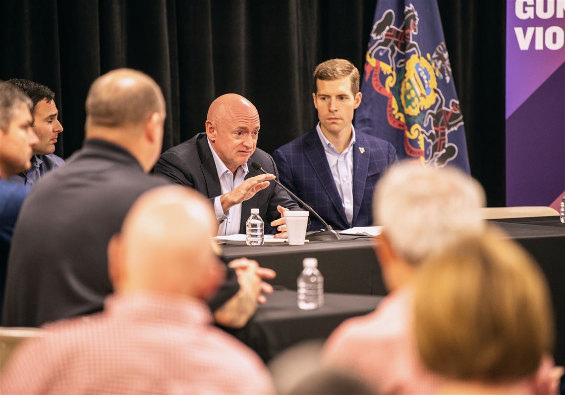 Capt. Mark Kelly, center, speaks about his experience with gun violence as U.S. Rep. Connor Lamb, right, listens, during a community panel discussion on gun violence Saturday at the Heidelberg Volunteer Fire Department.