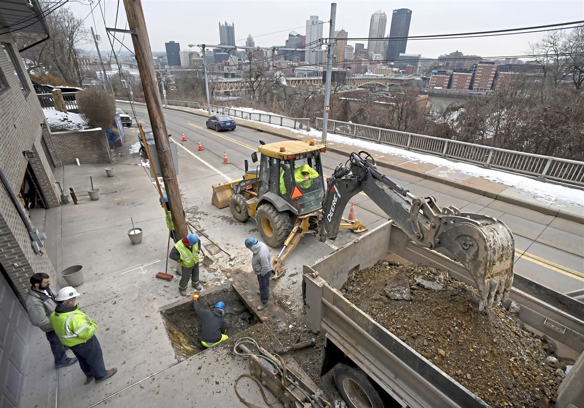 A  PWSA  crew work to locate the break in the service line or water main in the 400 block of Arlington Avenue overlooking the skyline, in this January 2019 file photo.  PWSA working to go digital, allowing plumbers to instantly upload photos of work, previously handled on paper.