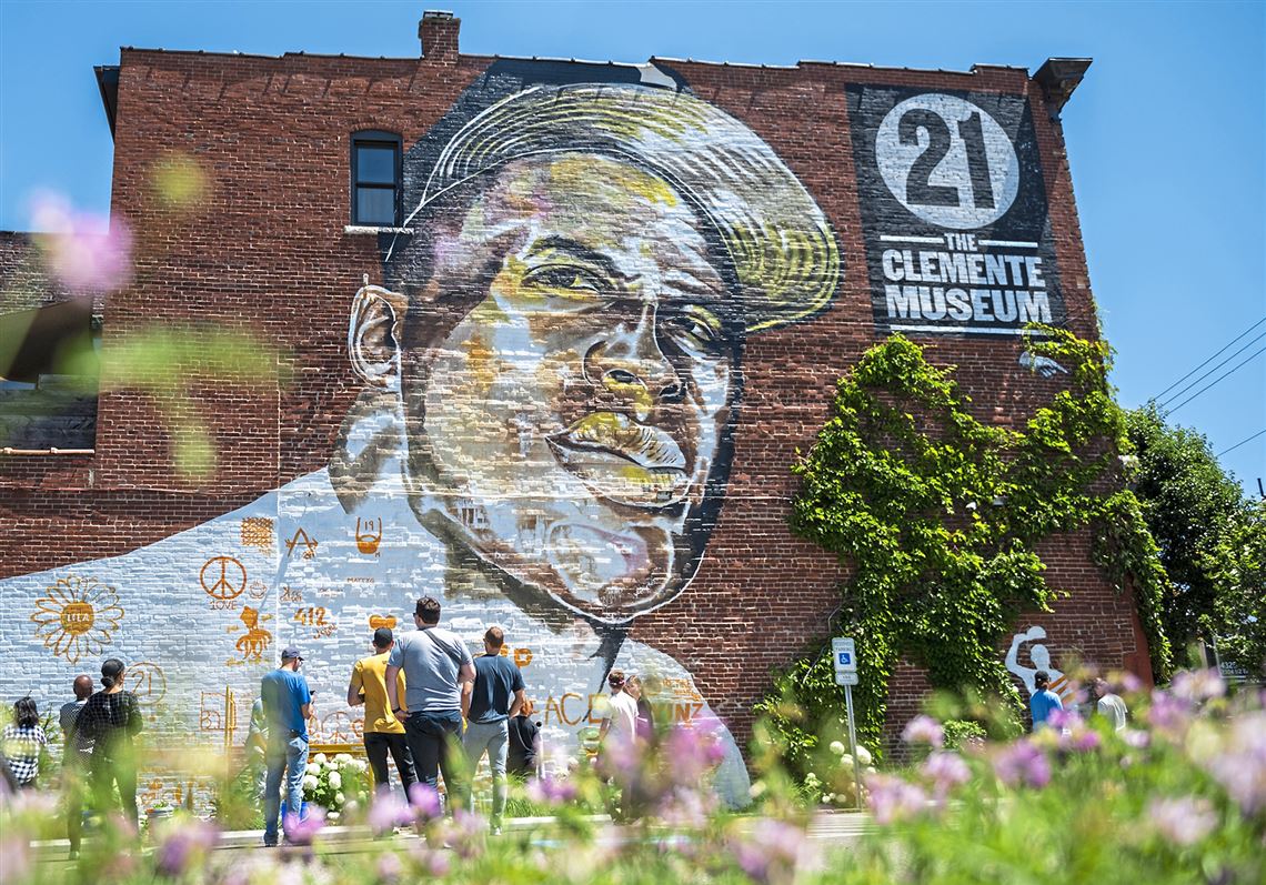 Students from the Manchester Craftsmen's Guild take a break from their work to inspect a mural of Roberto Clemente by artist Kyle Holbrook.