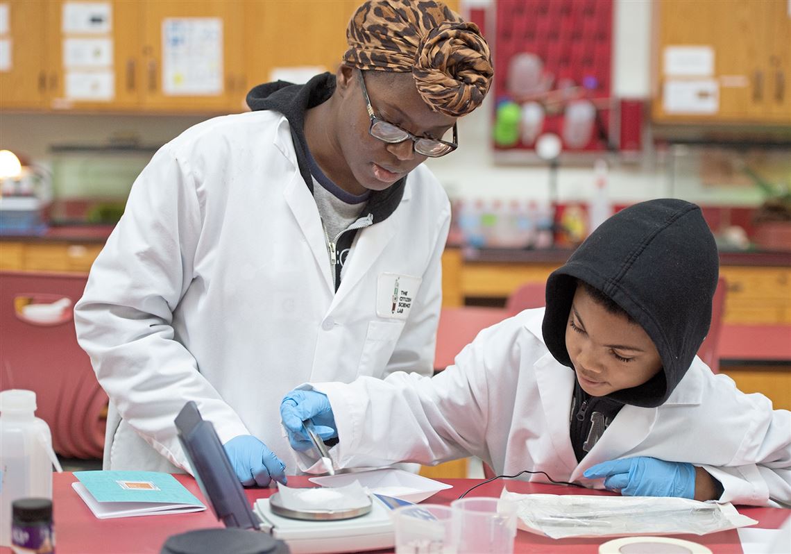 Under the watchful eye of Cynthia Thomas, STEM coordinator for the Citizen Science Lab, Ezekiel Brewer, 10, from Allentown, weighs lactase enzymes for an experiment during a Citizen Science Lab homeschool workshop in the Hill District in 2020.  