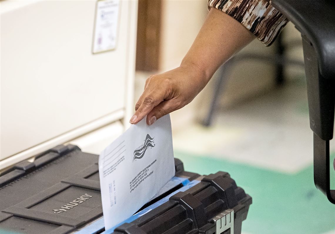 County worker Roberta Kava, of Carrick, puts a mail-in ballot in a secure box at the drop-off location in the Allegheny County Office Building, Monday, Nov. 1, 2021, Downtown. 