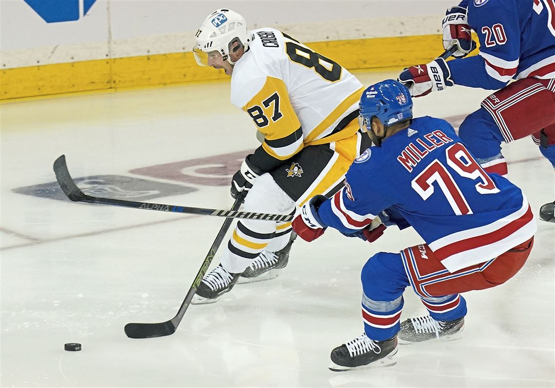 Pittsburgh Penguins center Sidney Crosby (87) punches New York Rangers  defenseman K'Andre Miller during the second overtime of Game 1 of an NHL  hockey Stanley Cup first-round playoff series Tuesday, May 3