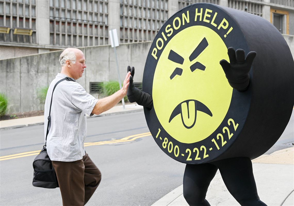 Mr. Yuk, worn by Emily Czapko, the program manager for the Pittsburgh Poison Center, high fives Ed Kuchar on Monday, July 17, 2023, outside the Pittsburgh Poison Center at UPMC in Oakland. 