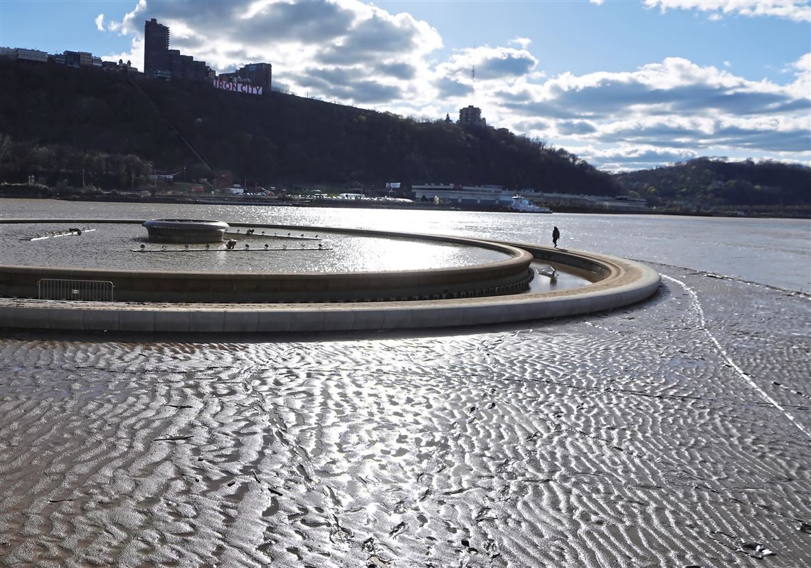A single park goer braves a thick layer of mud to walk around the Point State Park Fountain Downtown Saturday, April 6, 2024.