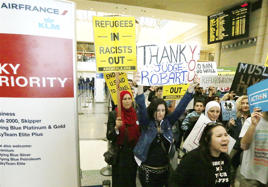 Demonstrators opposed to President Donald Trump's executive order barring travelers and immigrants from seven predominantly Muslim countries from entering the U.S. march Saturday through Tom Bradley International Terminal at Los Angeles International Airport. One sign thanks federal Judge James Robart, who issued a stay of the order.