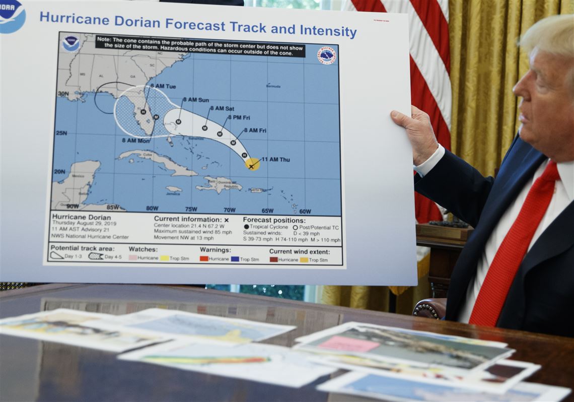President Donald Trump holds a chart as he talks with reporters after receiving a briefing on Hurricane Dorian in the Oval Office of the White House on Sept. 4, 2019, in Washington.