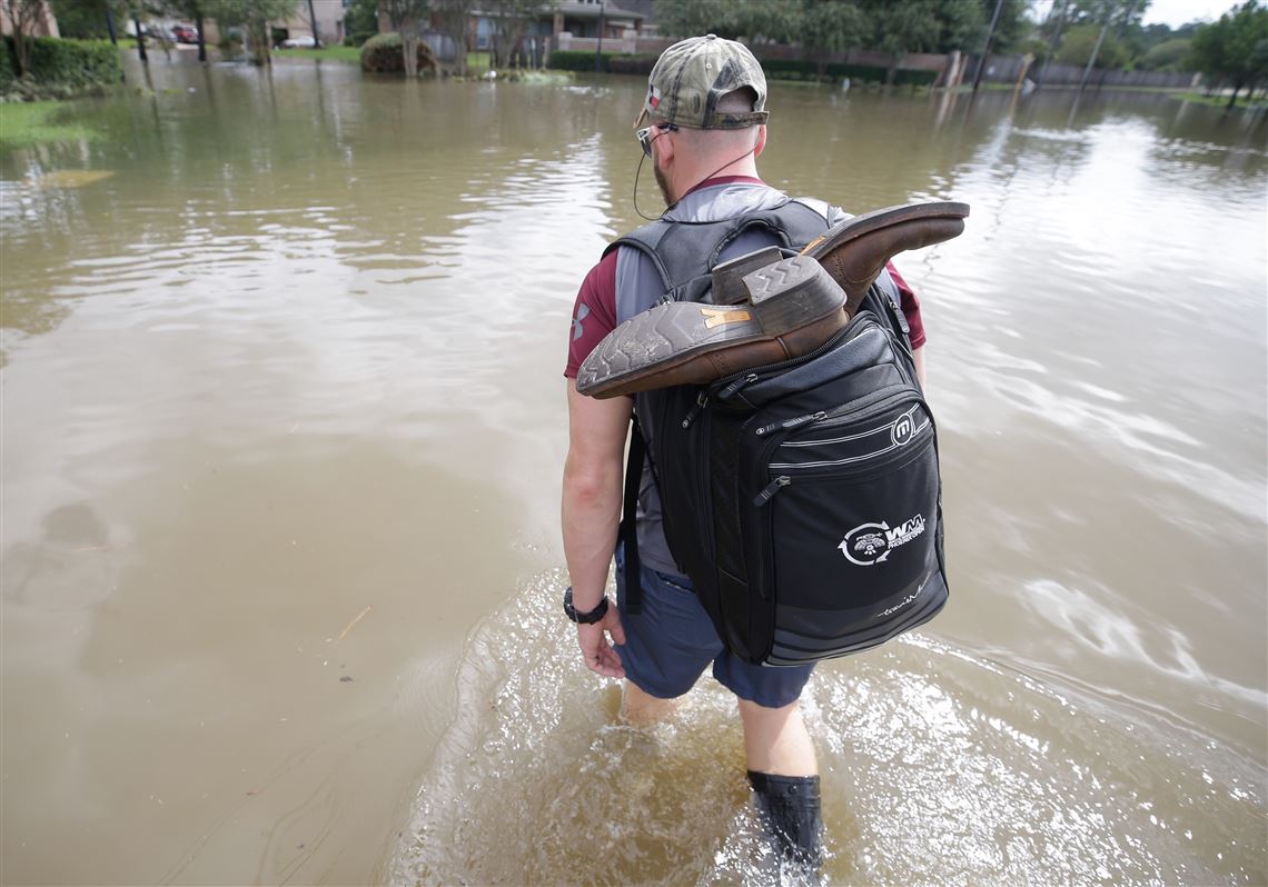 CORRECTS BYLINE - Robert Spooner, a U.S. Customs and Border patrol officer, center, and other volunteers work to prepare boats to help people in the aftermath of Harvey, Wednesday, Aug.30, 2017 in Houston. Harvey's floodwaters started dropping across much of the Houston area, but many thousands of homes in and around the nation's fourth-largest city were still swamped and could stay that way for days or longer. (Melissa Phillip/Houston Chronicle via AP)