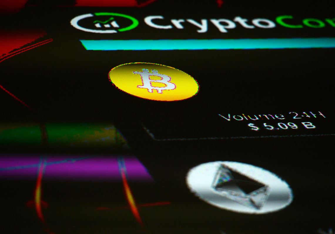 The symbols for Bitcoin and Ethereum cryptocurrency are displayed on a screen during the Crypto Investor Show in London on March 10, 2018. 