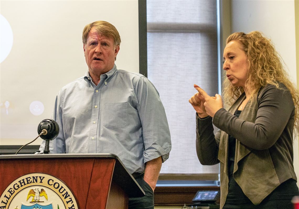 Allegheny County Executive Rich Fitzgerald speaks while an ASL interpreter, right, translates, during a press conference at the Allegheny County Health Department's administrative offices in Downtown.