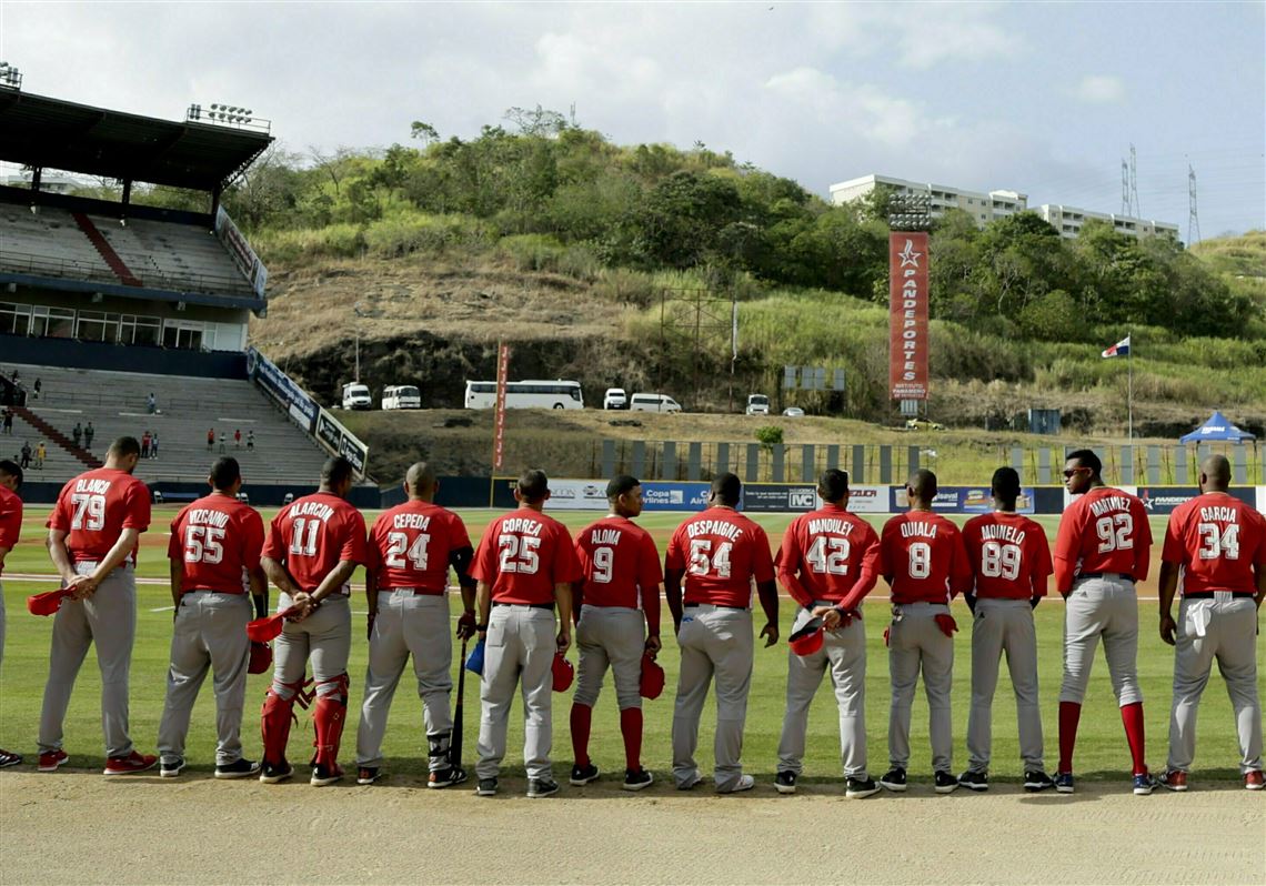 The Cuban baseball team listens to their national anthem at the