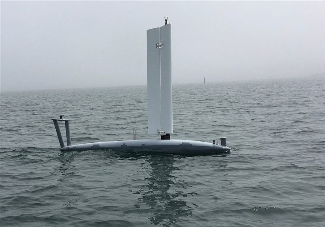 An Ocean Aero Submaran S10 parks itself on the ocean surface, sail extended.