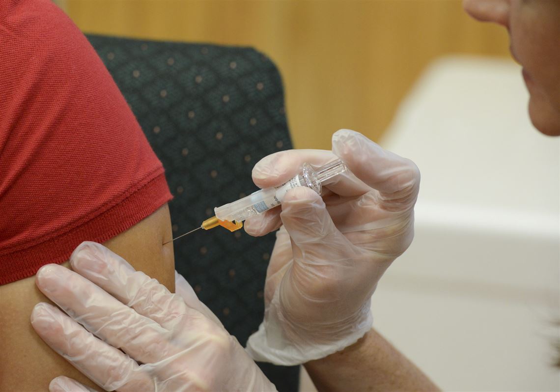 A woman receives a flu vaccine shot.