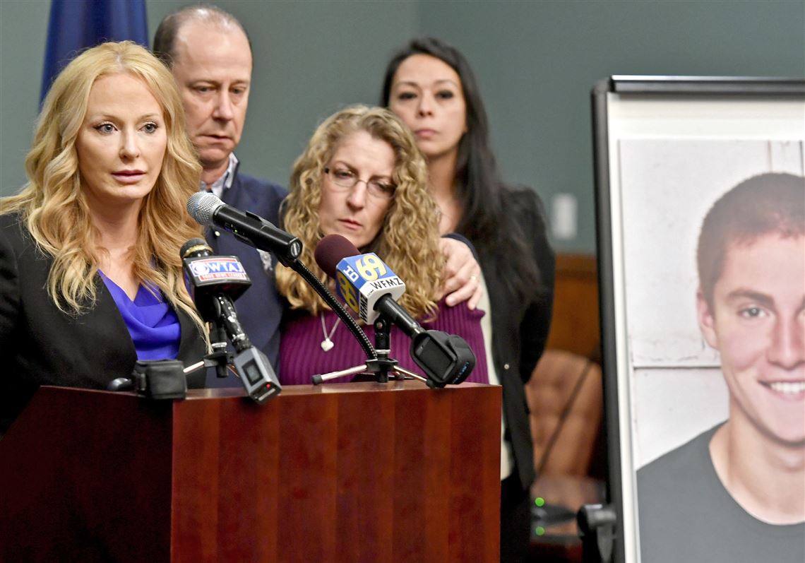 In this May 5, 2017, file photo, Centre County, Pa., District Attorney Stacy Parks Miller, left, announces findings an investigation into the death of Penn State University fraternity pledge Tim Piazza (in photo at right) as his parents, Jim and Evelyn Piazza, second and third from left, stand nearby during a news conference in Bellefonte, Pa. 