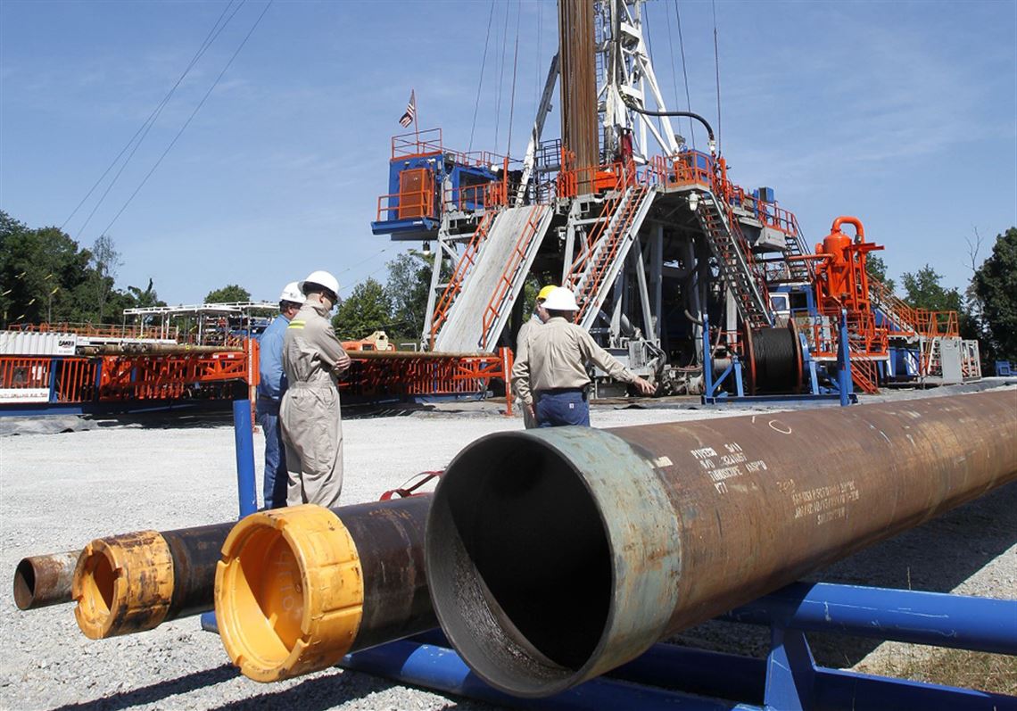 In this 2011 file photo, Range Resources workers stand near a rig that drills into shale at a well site in Washington, Pa.