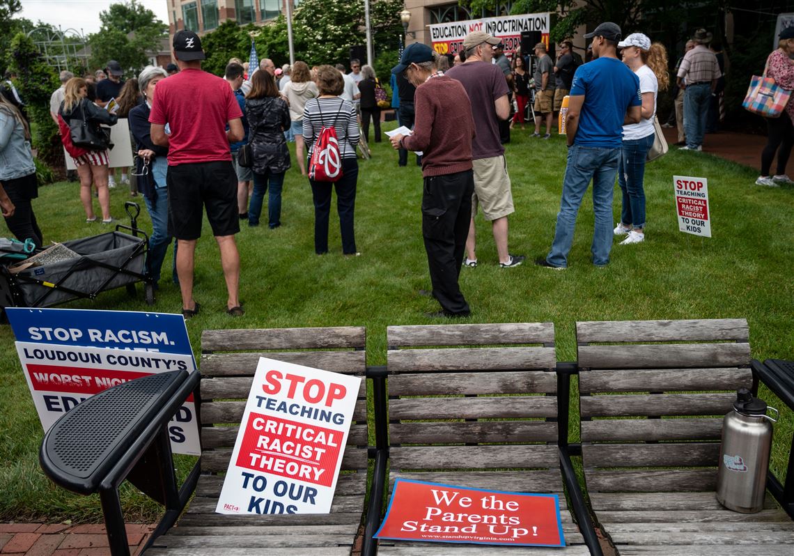 Signs are seen on a bench during a rally against "critical race theory" (CRT) being taught in schools at the Loudoun County Government center in Leesburg, Virginia on June 12, 2021. 