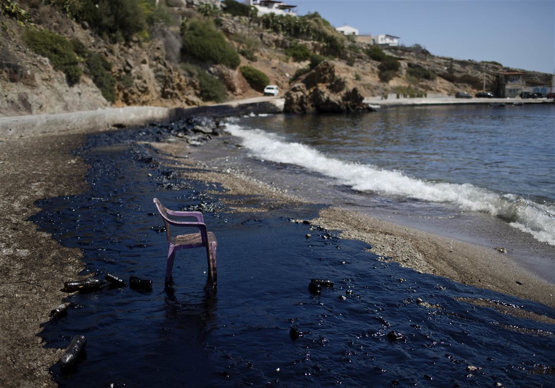 FILE - In this Tuesday, Sept. 12, 2017 file photo, a plastic chair on a polluted beach after an oil spill on the island of Salamina, Greece, near Athens. The World Wildlife Fund has filed a lawsuit in Greece over extensive pollution along Athens' coastline following the sinking of a tanker near the country's largest port of Piraeus, it was reported on Monday, Sept. 18, 2017. (AP Photo/Petros Giannakouris, File)