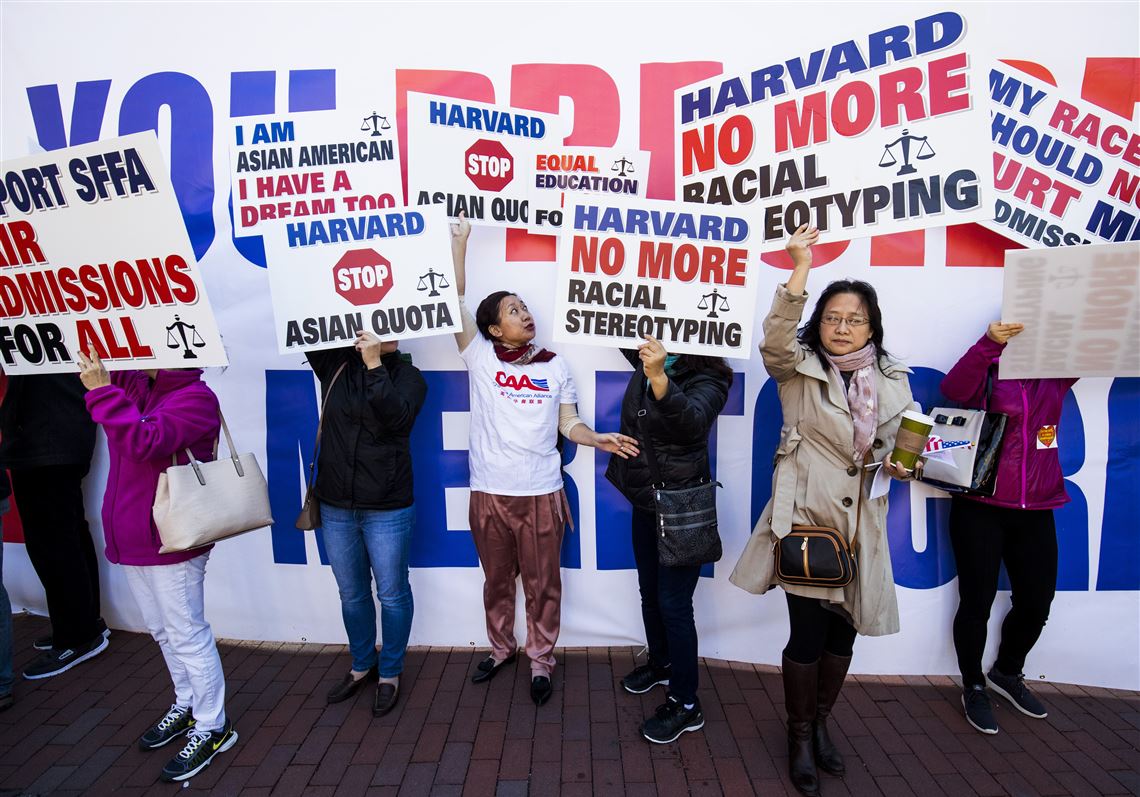 In this file photo, demonstrators hold signs during a protest against Harvard University's admission process at Copley Square in Boston on Oct. 14, 2018.