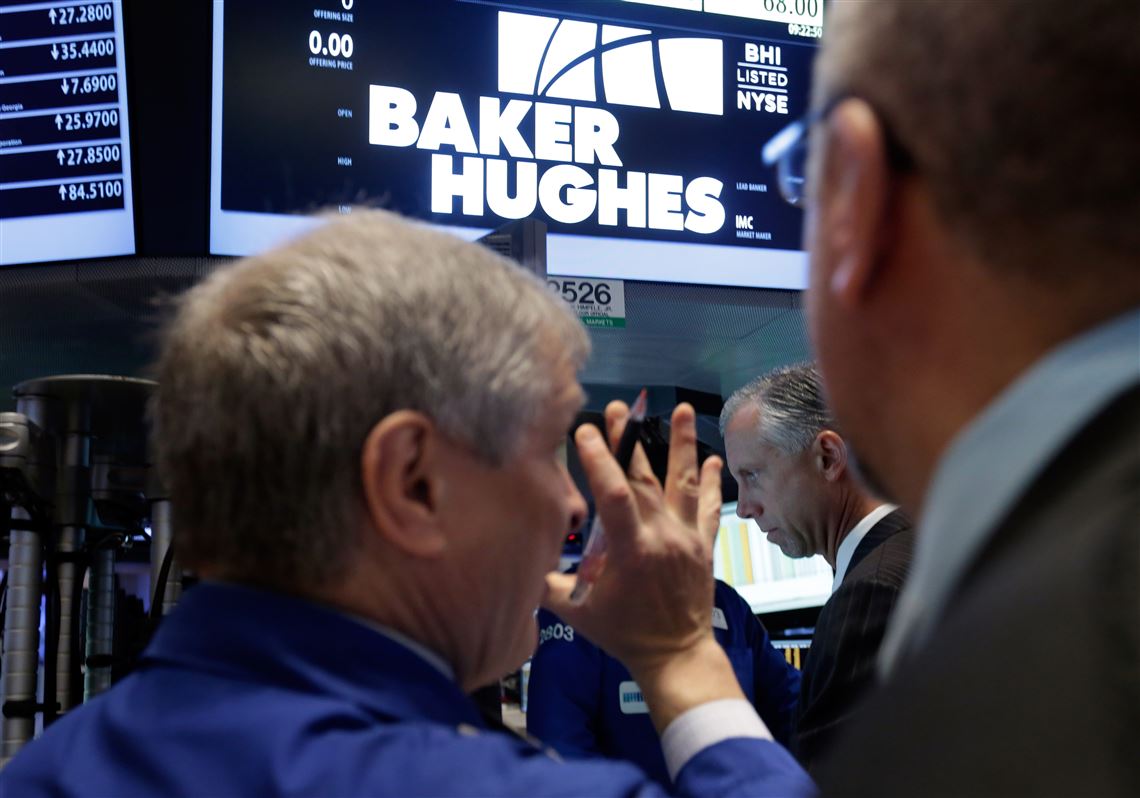 FILE - In this Nov. 17, 2014, file photo, traders gather at the post that handles Baker Hughes on the floor of the New York Stock Exchange. Two companies crucial to the business of U.S. energy exploration — Haliburton and Baker Hughes — have abandoned their planned merger. The Justice Department disclosed the plans on Sunday, May 1, 2016. (AP Photo/Richard Drew, File)