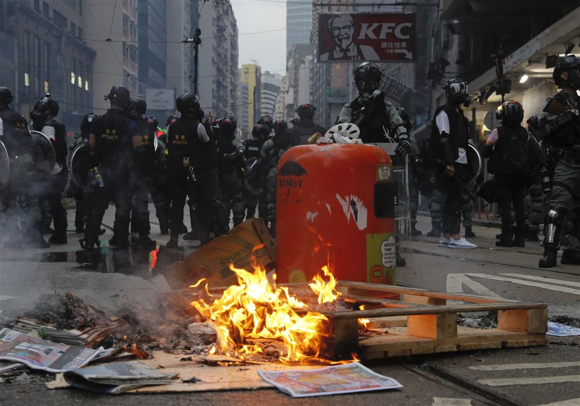 Police stand near fire made by protestors in Hong Kong, Sunday, Oct. 6, 2019. Shouting 