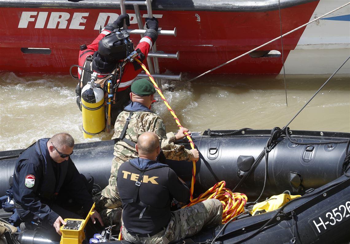 A diver descends a ladder to dive to the wreckage under Margaret Bridge in Budapest, Hungary, Friday, May 31, 2019. Seven people are confirmed dead and seven have been rescued, while 21 people remain missing in the waters. A South Korean group on a package tour of Europe â€” including 30 tourists, two guides and a photographerâ€” were on an hour-long sightseeing tour of Budapest when their boat collided with a Viking cruise ship during a downpour Wednesday evening. (AP Photo/Laszlo Balogh)