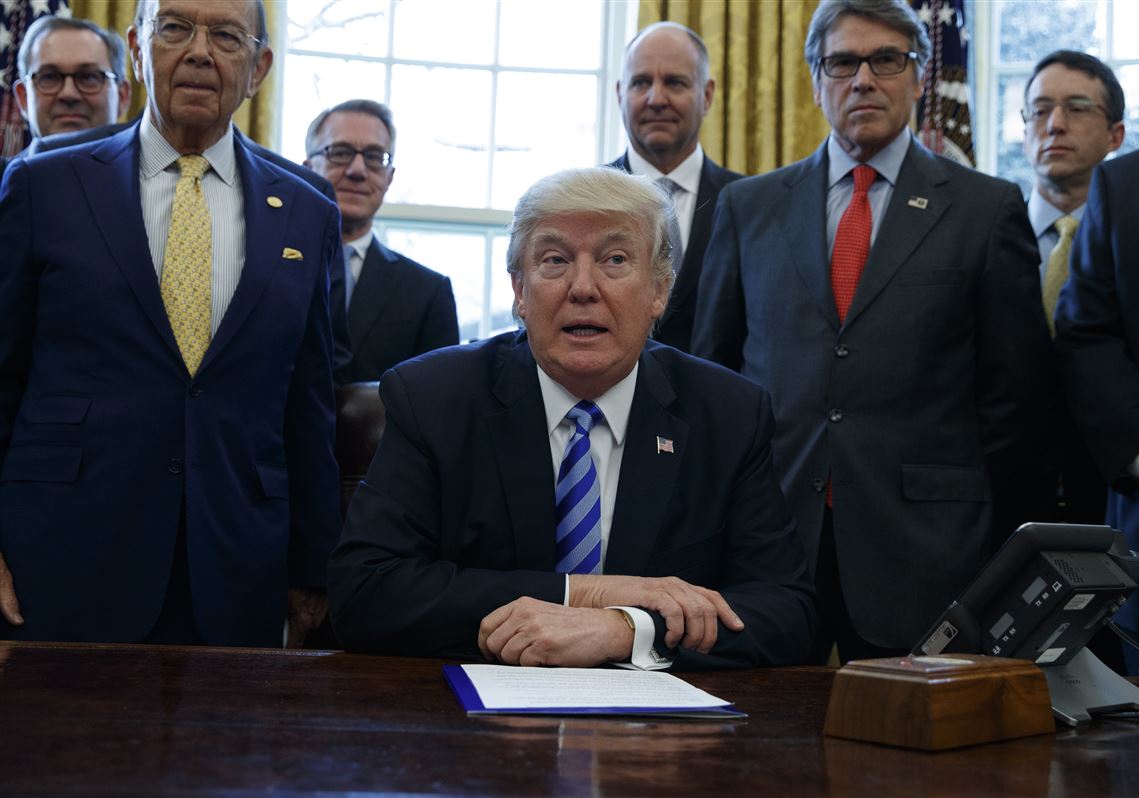 FILE - This March 24, 2017, file photo shows President Donald Trump, flanked by Commerce Secretary Wilbur Ross, left, and Energy Secretary Rick Perry, announcing the approval of a permit to build the Keystone XL pipeline, clearing the way for the $8 billion project in the Oval Office of the White House in Washington. Attorneys for the Trump administration are due in a Montana courtroom Thursday, May 24, 2018, to defend the approval of TransCanadaâ€™s disputed Keystone XL oil sands pipeline project. (AP Photo/Evan Vucci, file)
