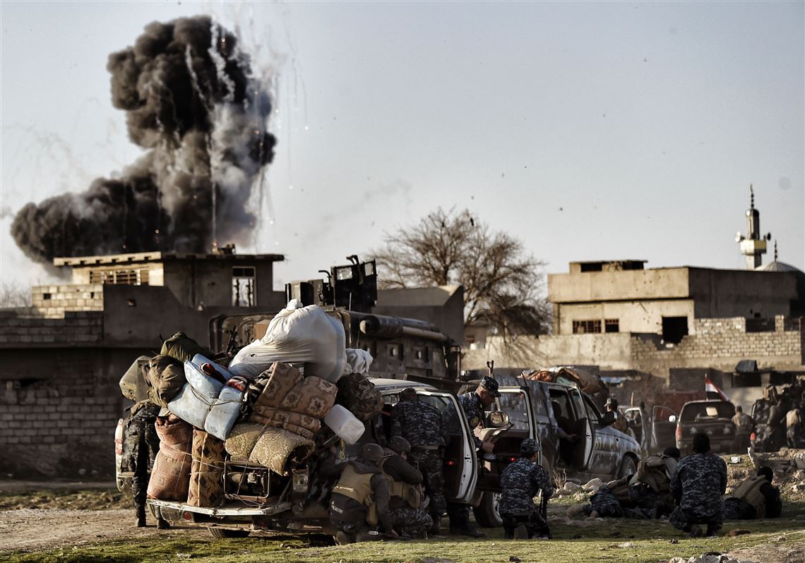 Iraqi Federal police members take cover as smoke billows from a big explosion during fighting between Iraqi troops and fighters of the Islamic State group, in Mosul on Friday.