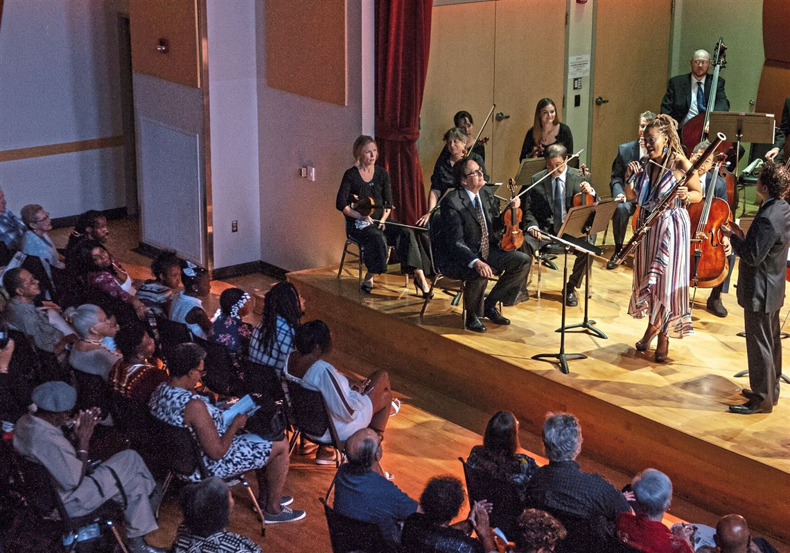 Bassoonist Monica Ellis speaks to the crowd after playing with members of the Pittsburgh Symphony Orchestra on July 31, 2018 in the Elsie H. Hillman Auditorium at the Kaufmann Center in Crawford-Roberts. Ellis is a Hill District native and the program played helps celebrates the history of the Hill District. 