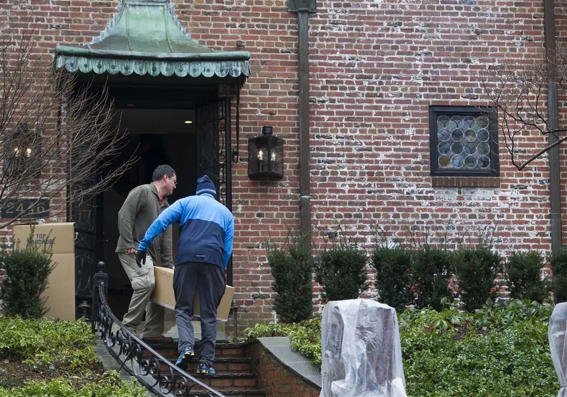 FILE - In this Tuesday, Jan. 17, 2017 file photo, movers, under the supervision of White House ushers, move President Barack Obama's family's belongings into their rented house in the Kalorama neighborhood of Washington. On Friday, Dec. 22, 2017, The Associated Press reported that stories circulating on the internet about the FBI executing a search warrant at the residence are untrue. (AP Photo/Cliff Owen)