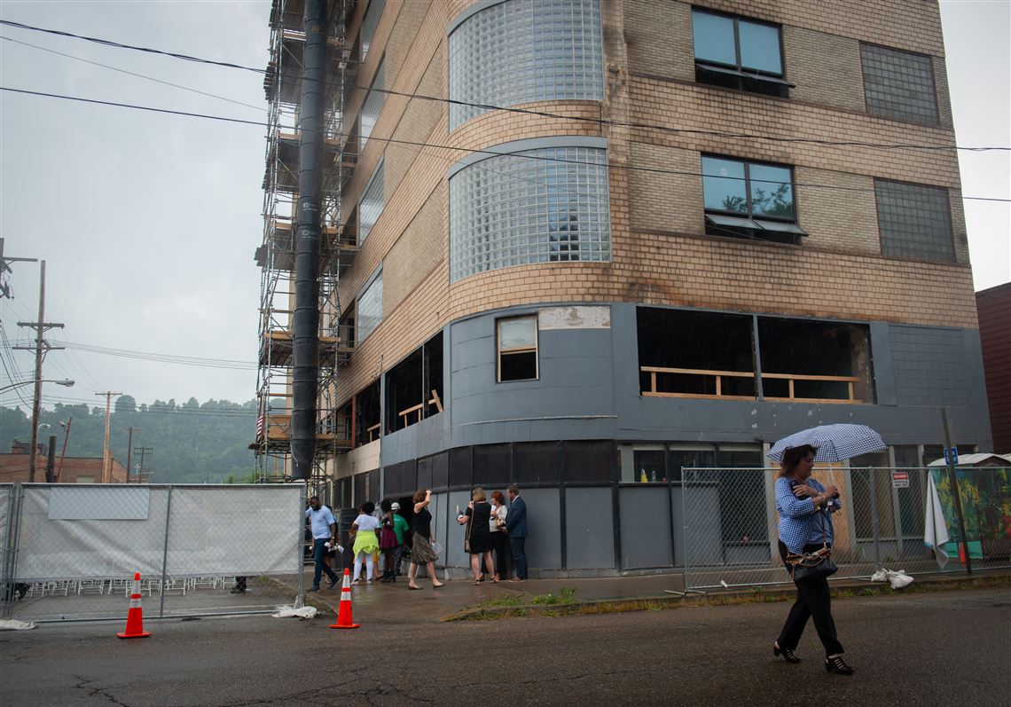 Attendees leave as it begins to rain at a groundbreaking event at the former Ohringer building in Braddock, which is going to be converted into a residence for artists.