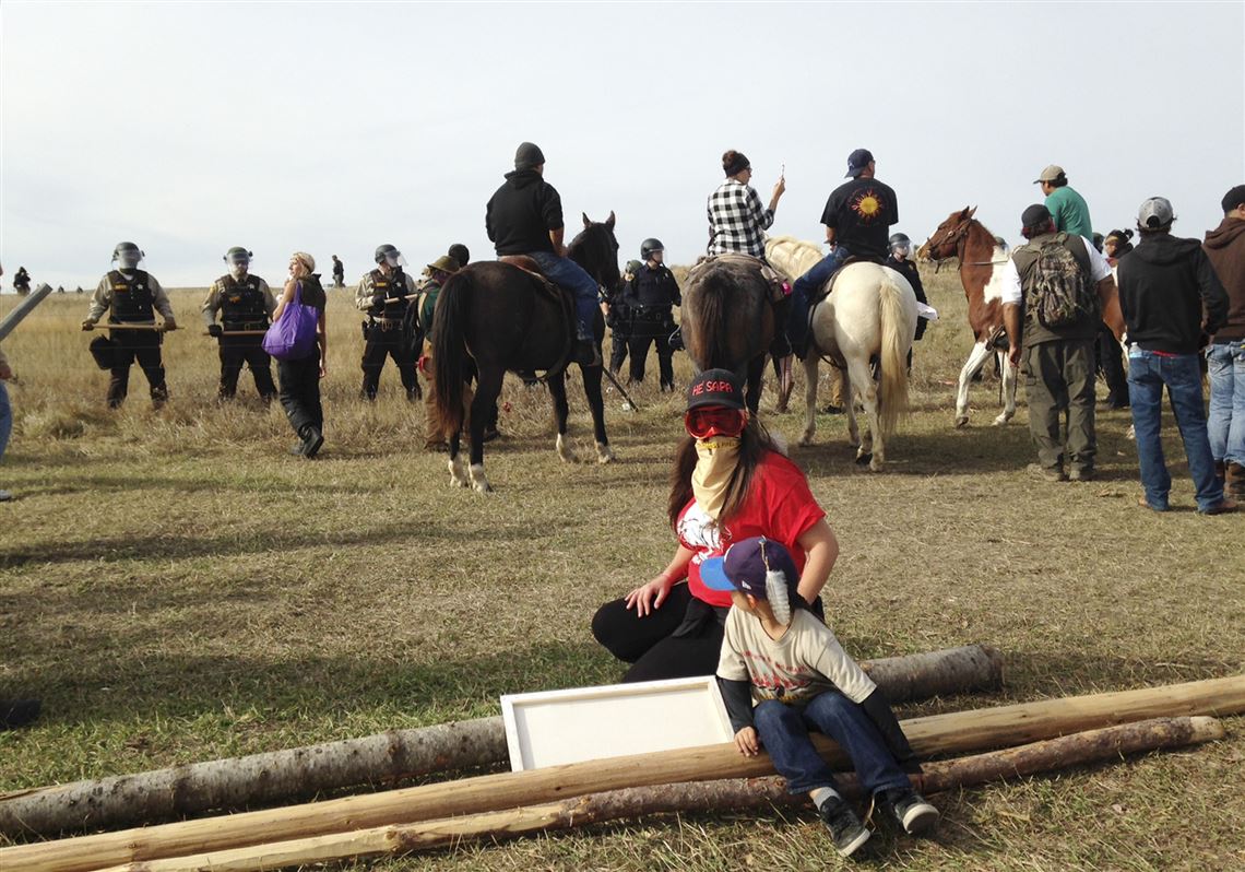 Protesters against the construction of the Dakota Access oil pipeline block a highway in near Cannon Ball, N.D., on Wednesday, Oct. 26, 2016. Law enforcement officials have asked people protesting the Dakota Access oil pipeline to vacate an encampment on private land, and the protesters said no. Protesters are trying to halt construction of the pipeline they fear will harm cultural sites and drinking water for the Standing Rock Sioux. (AP Photo/James MacPherson)