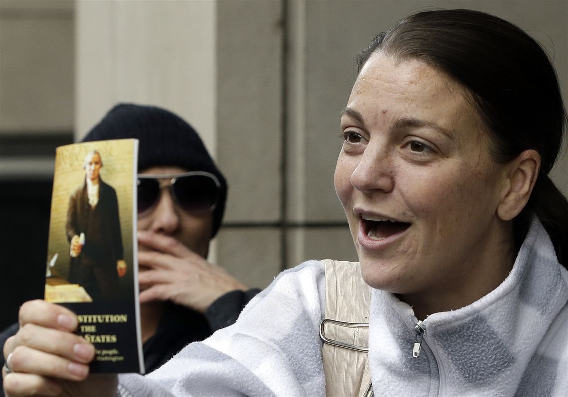 A supporter holds a copy of the constitution after hearing a verdict outside federal court in Portland, Ore., Thursday. A jury exonerated brothers Ammon and Ryan Bundy and five others of conspiring to impede federal workers from their jobs at the Malheur National Wildlife Refuge.