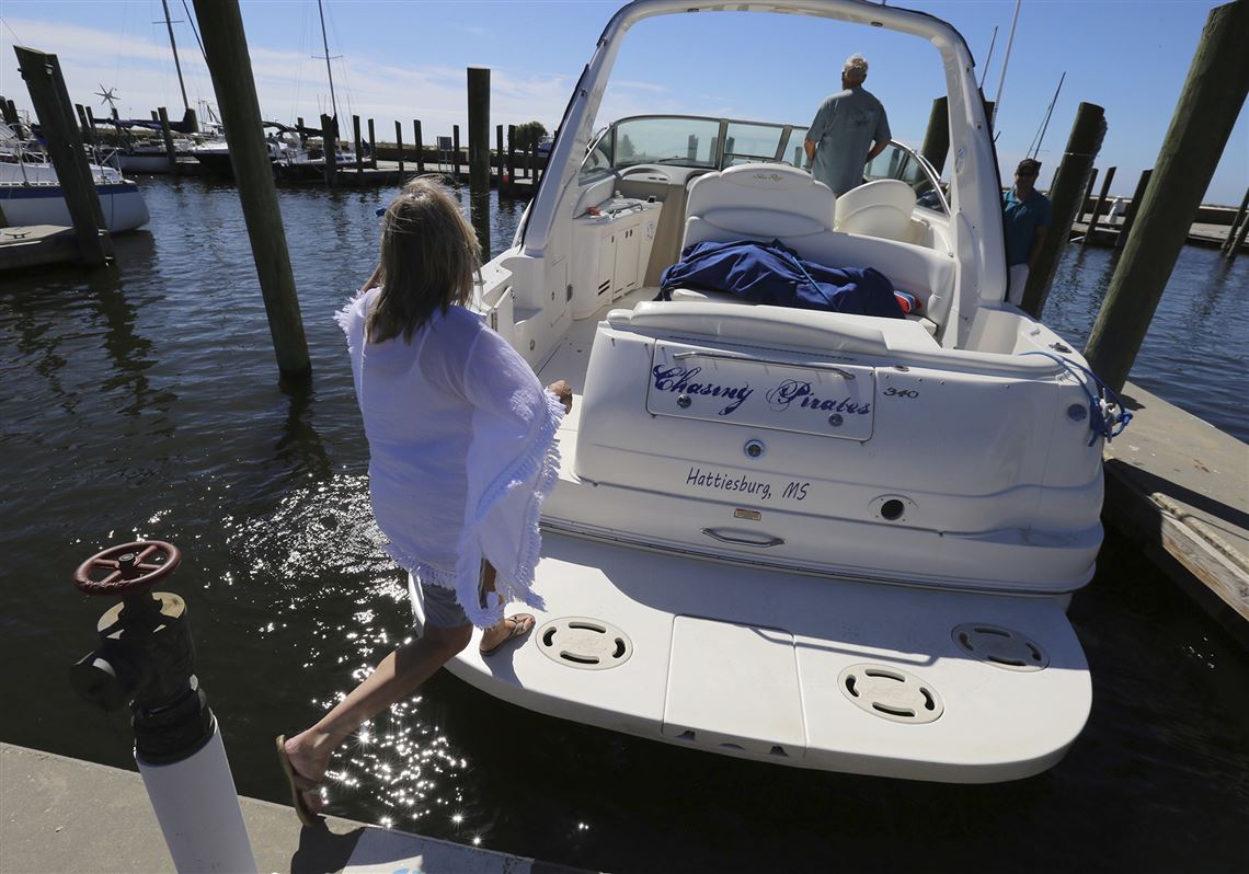 Brenda Kent jumps on her boat as she and her husband leave the Biloxi Small Craft Harbor in Biloxi, Miss., on Friday, Oct. 6, 2017 to take the boat up river in advance of Tropical Storm Nate.  Gulf Coast residents were bracing Friday for a fast-moving blast of wind, heavy rain and rising water as Tropical Storm Nate threatened to reach hurricane strength before a weekend landfall.   (John Fitzhugh/The Sun Herald via AP)