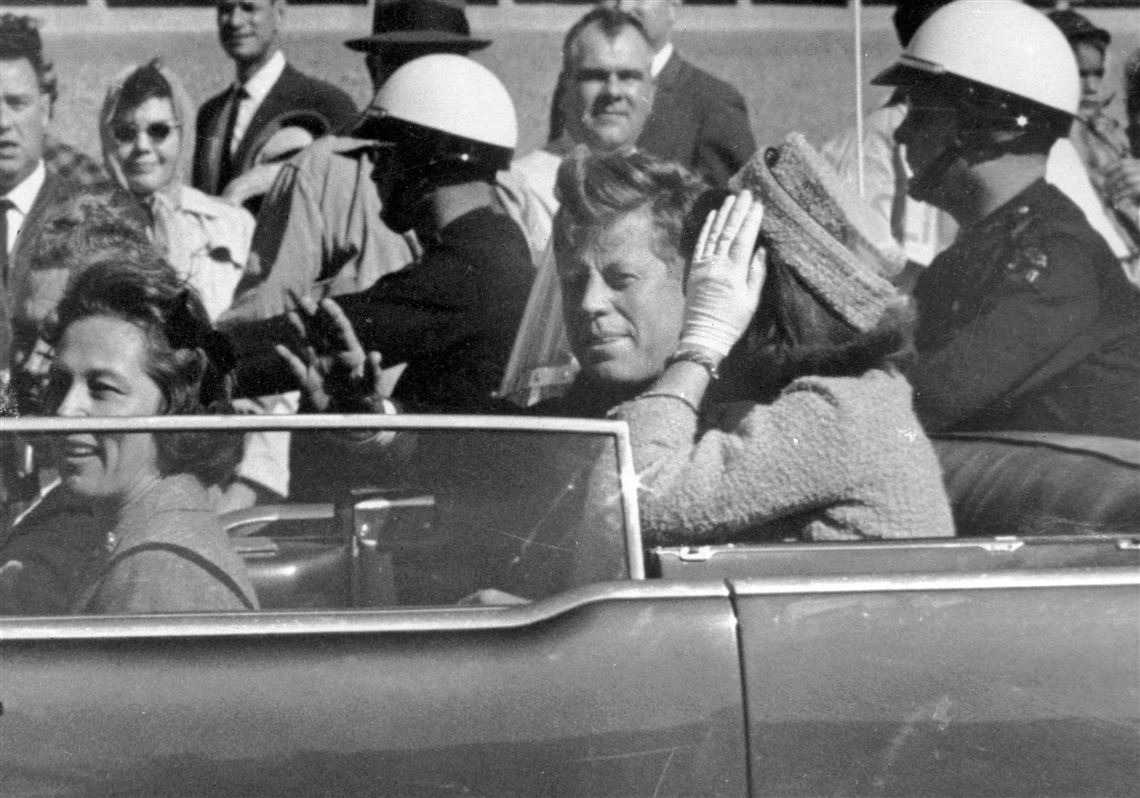 In this Nov. 22, 1963 file photo, President John F. Kennedy waves from his car in a motorcade in Dallas. Riding with Kennedy are First Lady Jacqueline Kennedy, right, Nellie Connally, second from left, and her husband, Texas Gov. John Connally, far left.  