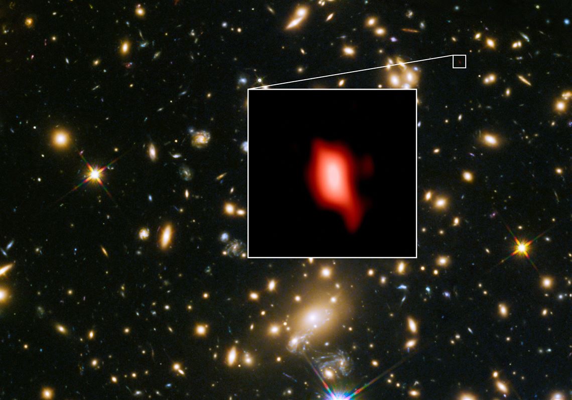 This image shows the galaxy cluster MACS J1149.5+2223 taken with the NASA/ESA Hubble Space Telescope; the inset image is the very distant galaxy MACS1149-JD1, seen as it was 13.3 billion years ago and observed with ALMA. Here, the oxygen distribution detected with ALMA is depicted in red.