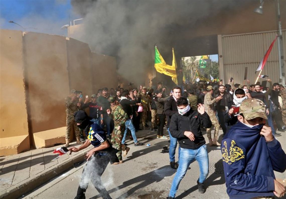 U.S. soldiers fire tear gas towards protesters who broke into the U.S. Embassy compound, in Baghdad, Iraq, Tuesday, Dec. 31, 2019. Dozens of angry Iraqi Shiite militia supporters broke into the U.S. Embassy compound in Baghdad on Tuesday after smashing a main door and setting fire to a reception area, prompting tear gas and sounds of gunfire.  