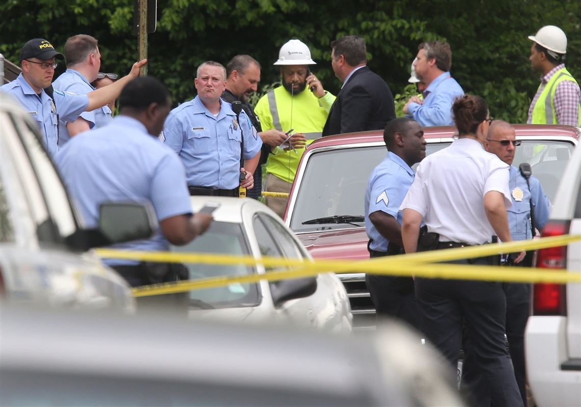 A Laclede Gas Co. worker takes down police tape so equipment could leave the crime scene, Thursday, April 20, 2017 in St. Louis. Police say a gunman opened fire on two utility workers, killing both of them, before fatally shooting himself. (J.B. Forbes/St. Louis Post-Dispatch via AP)
