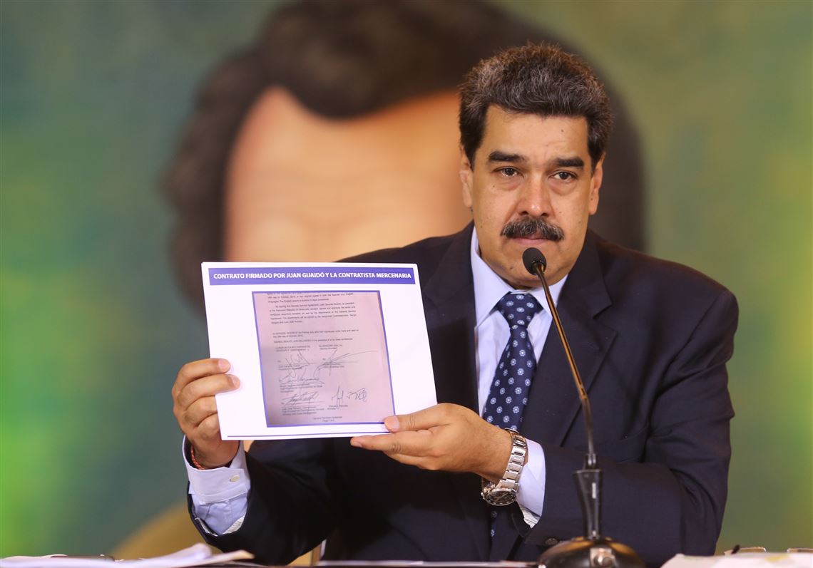 In this photo released by the Venezuela's Miraflores presidential press office, President Nicolas Maduro on Wednesday accuses opposition leader Juan Guaido of being behind a military raid designed to oust him.