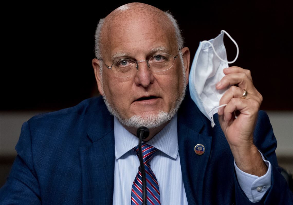 Centers for Disease Control and Prevention Director Dr. Robert Redfield holds up his mask as he speaks at a Senate Appropriations subcommittee hearing on a 