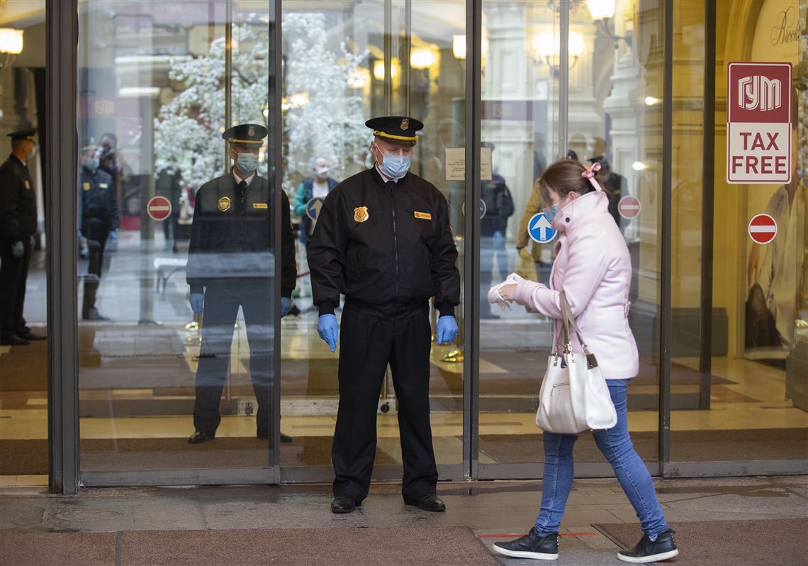 Security guards wearing face masks and gloves to protect from the coronavirus stand at an entrance of the GUM state department store after reopening in Moscow on Monday.