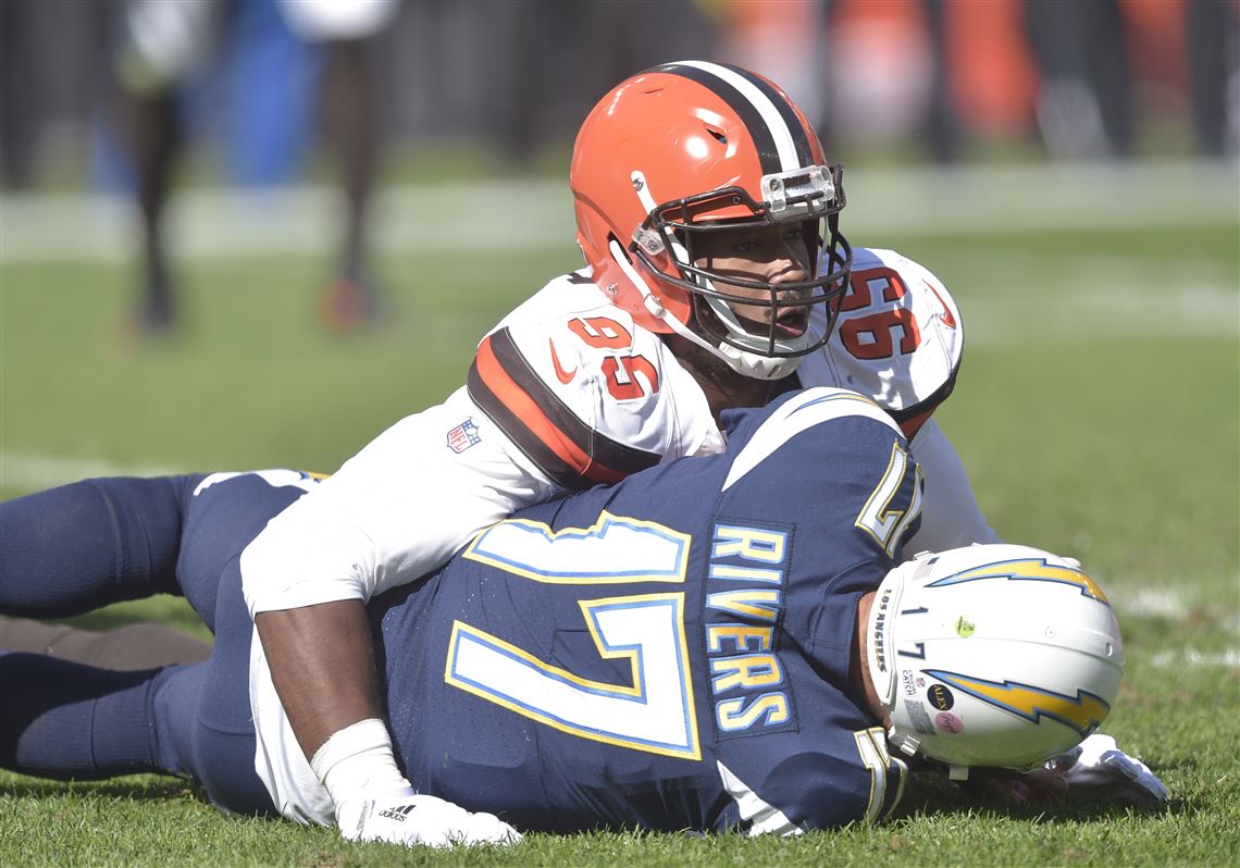 Cleveland Browns defensive end Myles Garrett, left, is restrained