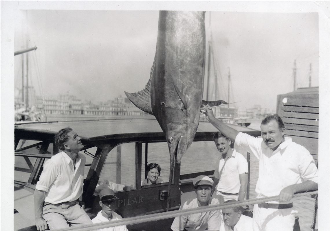 Ernest Hemingway (right), wife Pauline (center) and friends and crew on his cabin cruiser Pilar in Havana with a 324-pound marlin 9 August 1934. 