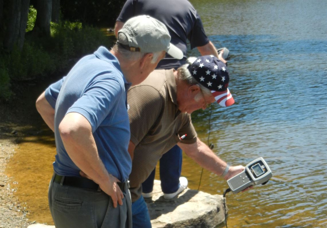 Senior Environment Corps volunteers Terry Boyer, left, and Joe Ryan check water quality samples from Sweet Arrow Lake in Schuylkill County. 